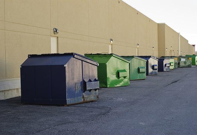 construction workers throw waste into a dumpster behind a building in Allgood AL